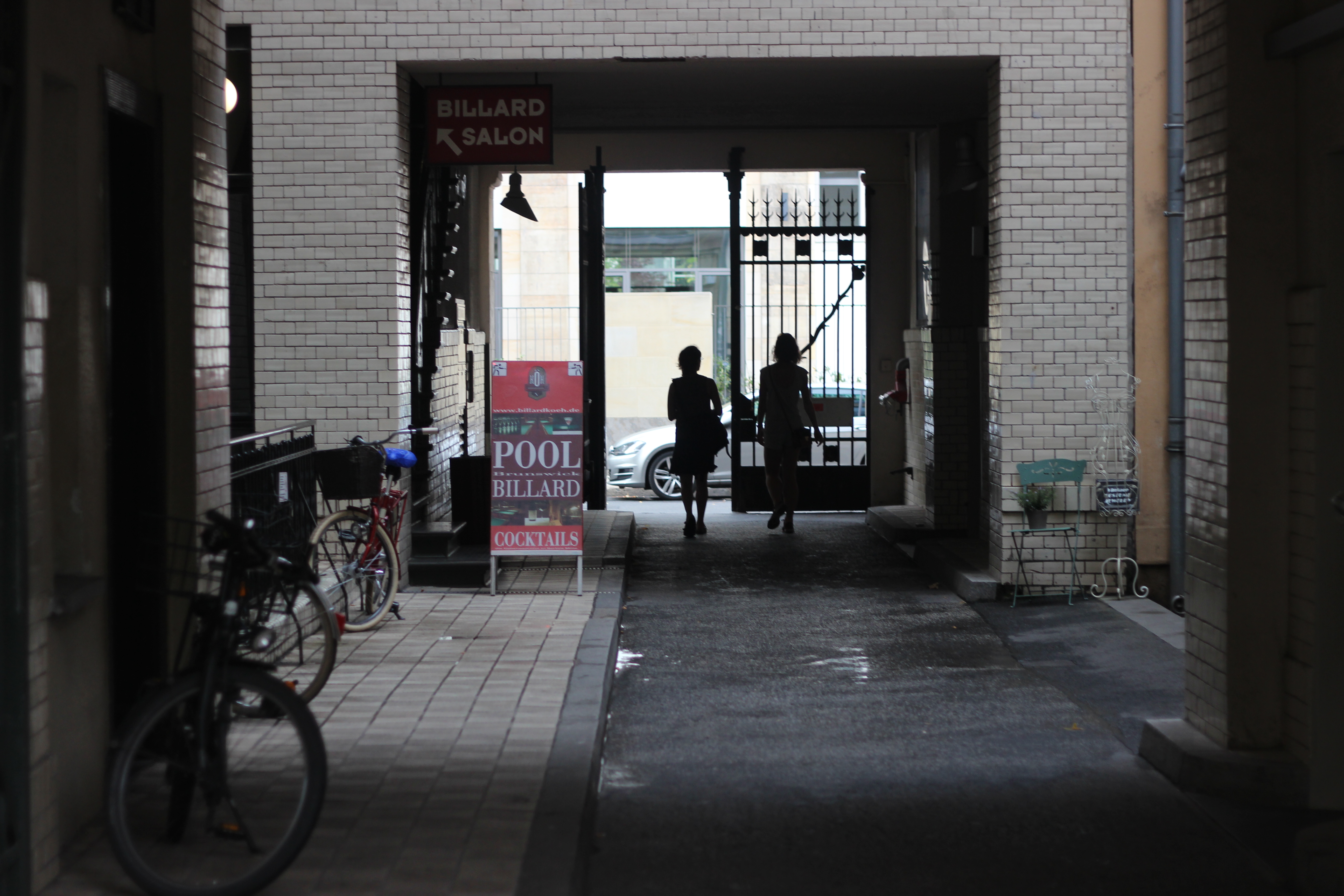 Two figures walking out through an archway into light, Berlin