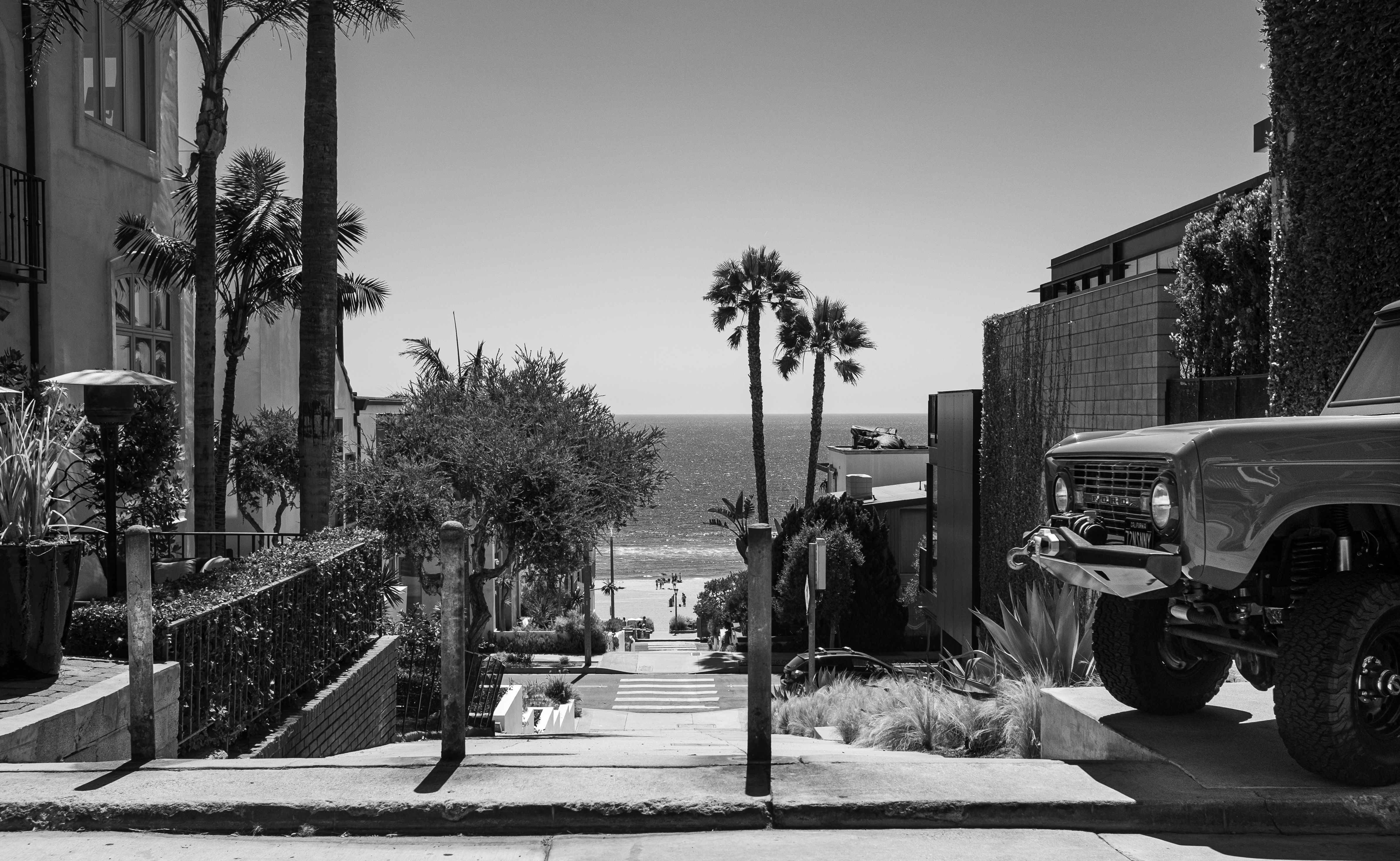 View down a walk street to the ocean past a vintage Ford Bronco, Manhattan Beach