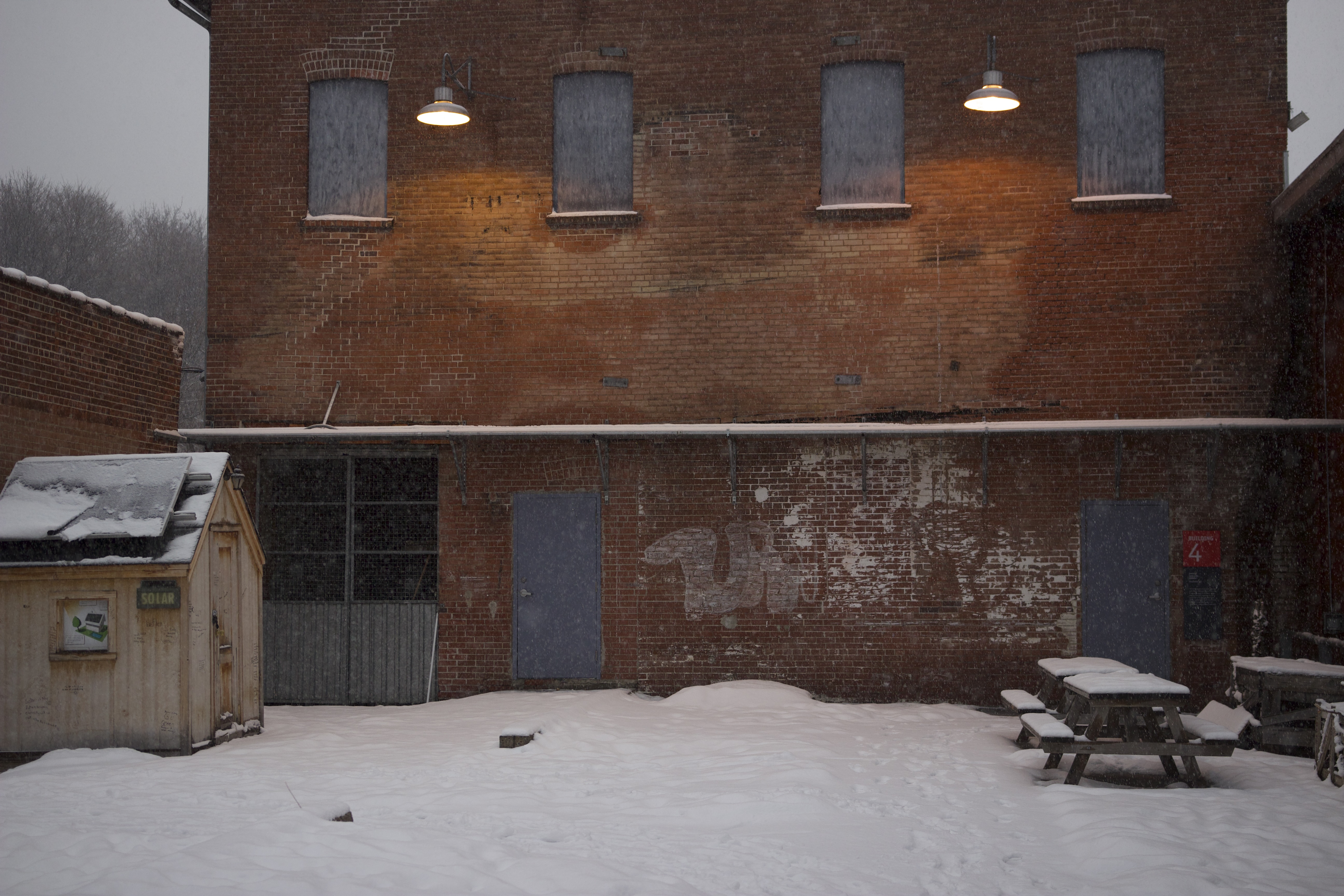 Snow falling on a brick courtyard at dusk, Toronto